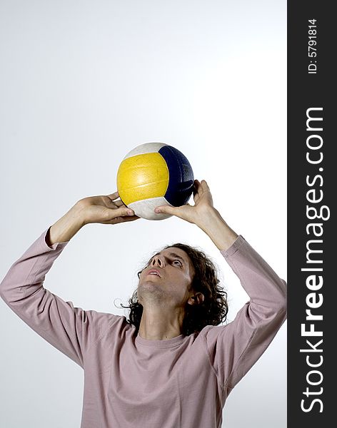 Man concentrated as he sets a volleyball. Vertically framed photograph. Man concentrated as he sets a volleyball. Vertically framed photograph.