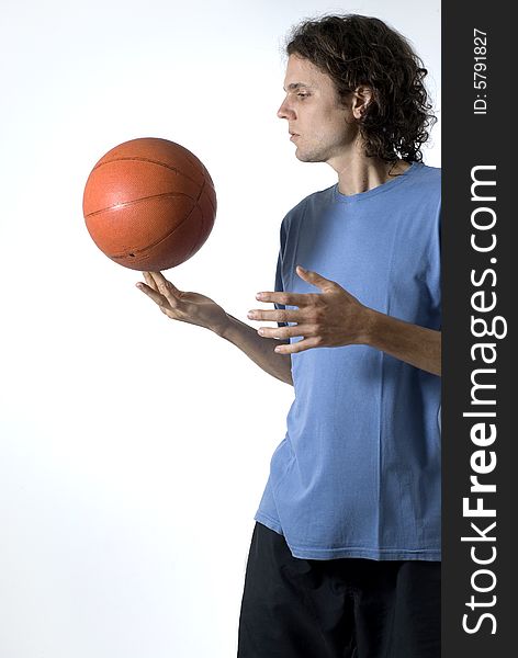 Man balances a basketball on his finger - Vertically framed photograph. Man balances a basketball on his finger - Vertically framed photograph