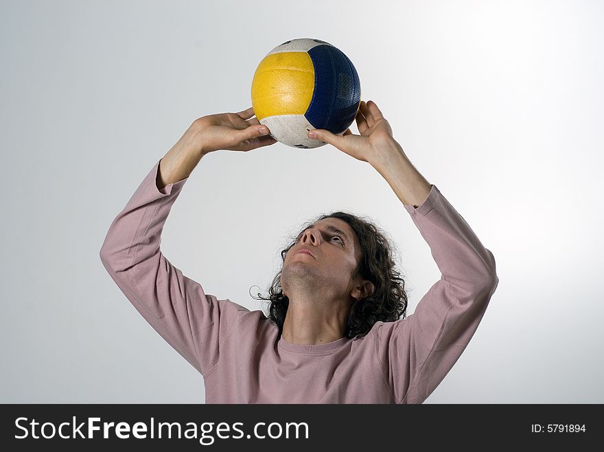 A man, standing, acts as if he were to set a volleyball up. Horizontally framed shot. A man, standing, acts as if he were to set a volleyball up. Horizontally framed shot.