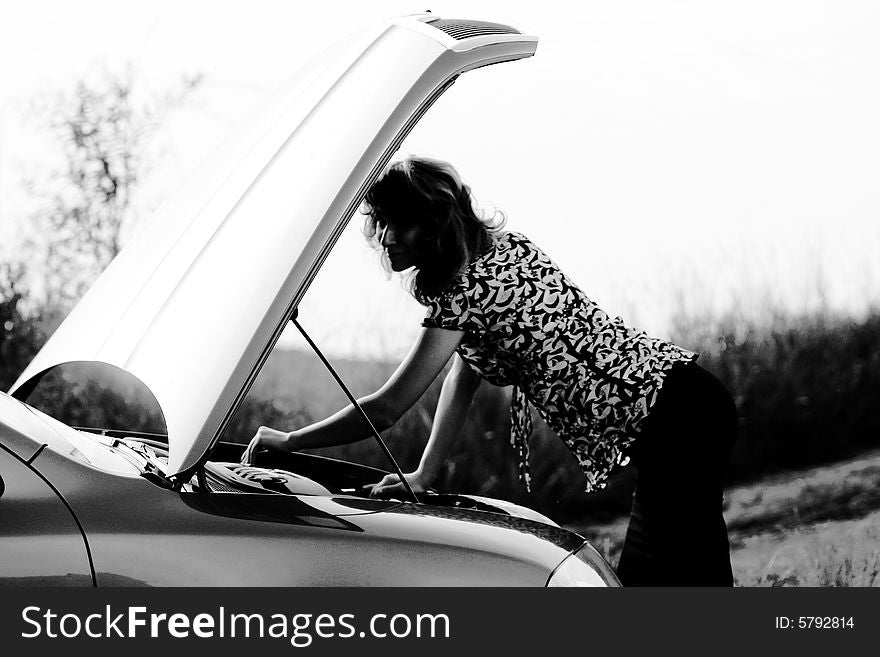 A sexy girl trying to repair the car