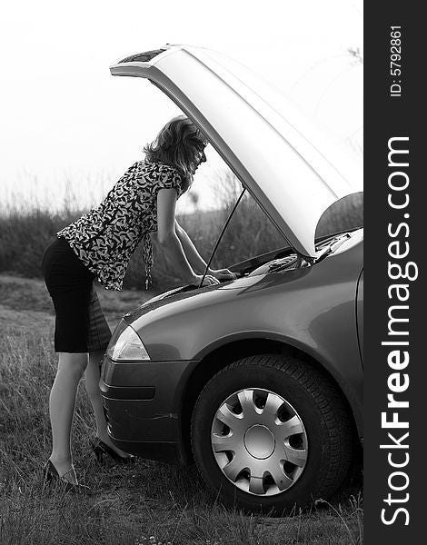 A sexy girl trying to repair the car