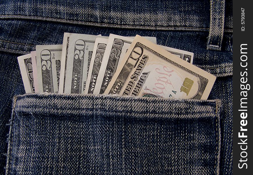 The dollars bills in a jeans pocket. The dollars bills in a jeans pocket