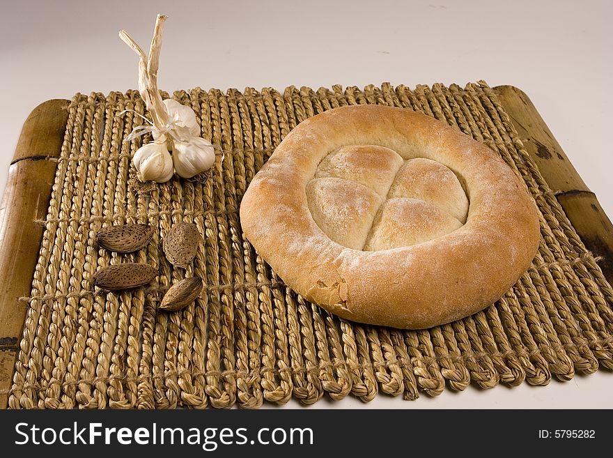 Made in the studio, bread, garlic and almonds on wood isolated on white; healthy food