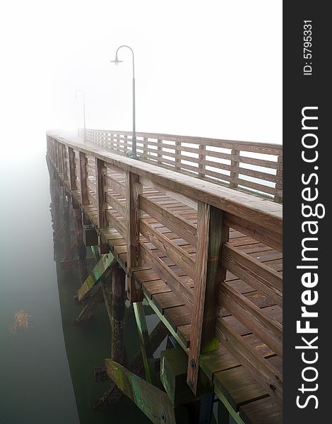 View of empty fishting pier in fog. View of empty fishting pier in fog.