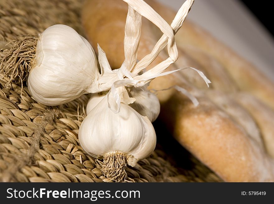 Garlic, made in the studio; healty medicine; bread in the background. Garlic, made in the studio; healty medicine; bread in the background