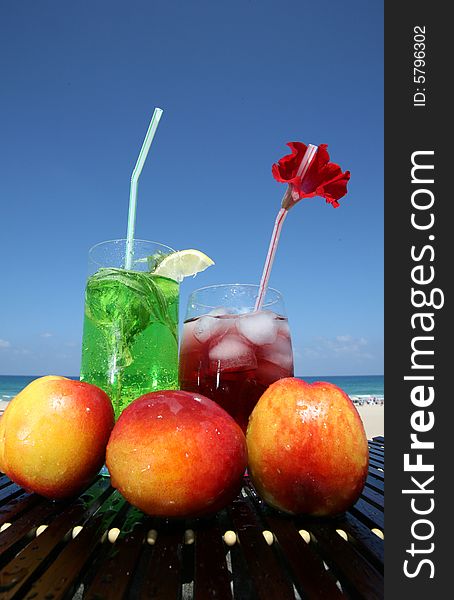 Green and red drink with icecubes in glasses on the blue sky backgraunds. Green and red drink with icecubes in glasses on the blue sky backgraunds
