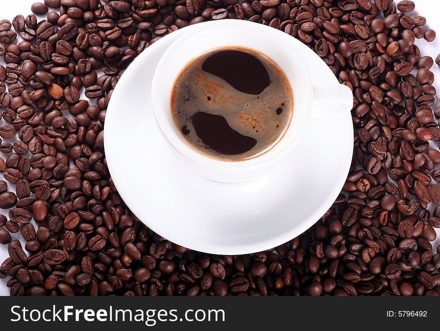 White cup with coffee on background with coffee beans. White cup with coffee on background with coffee beans