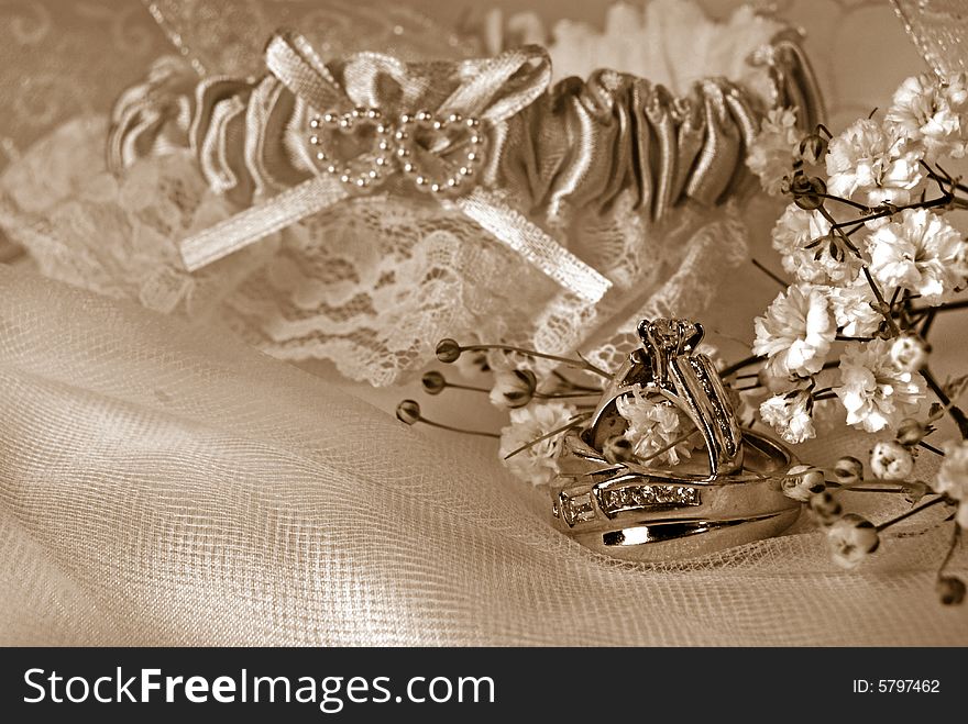 Wedding rings and garter on tulle in sepia. Wedding rings and garter on tulle in sepia.