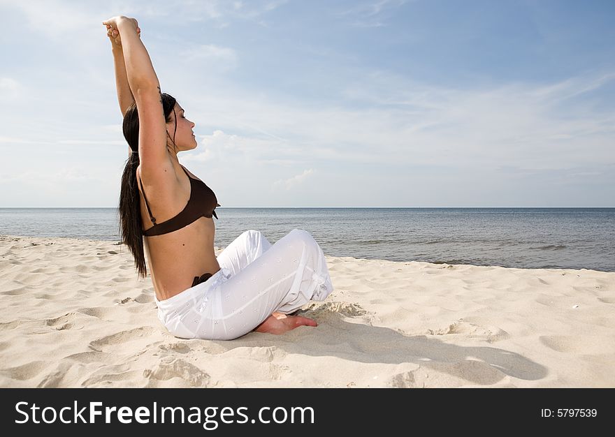 Active woman doing exercise on the beach