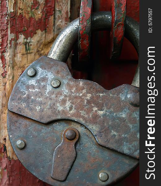 The closed, old, rusty hinged lock. A close up. The closed, old, rusty hinged lock. A close up