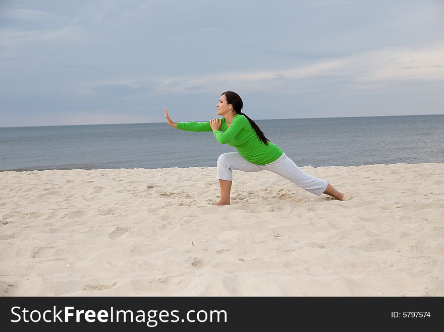 Active woman doing exercise on the beach