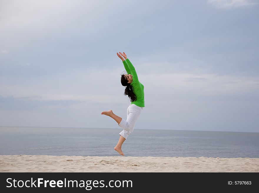 Active woman jumping on the beach. Active woman jumping on the beach