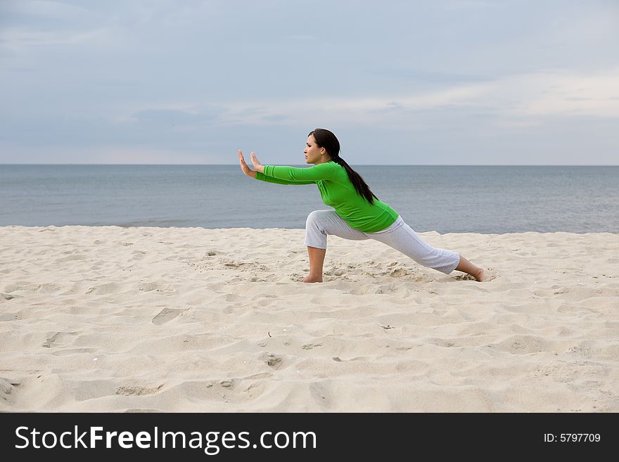 Active woman doing exercise on the beach