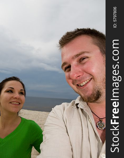 Active couple relaxing on the beach. Active couple relaxing on the beach