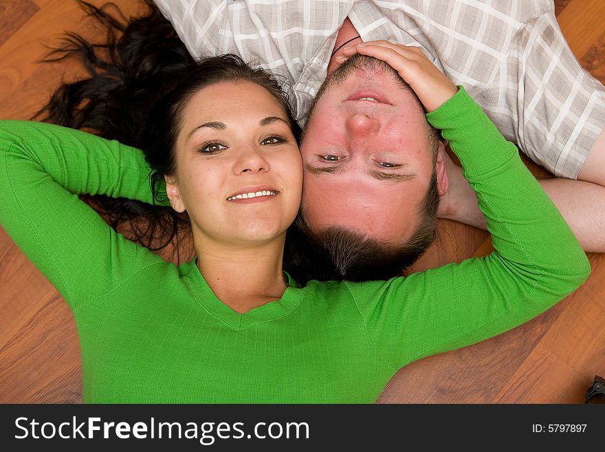 Happy couple lying on floor