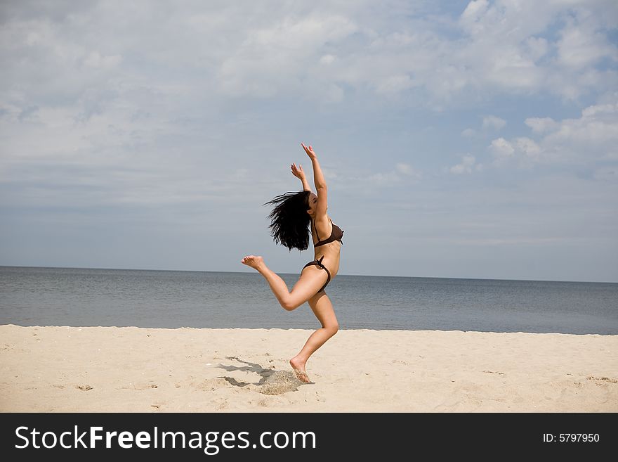 Active woman jumping on the beach. Active woman jumping on the beach