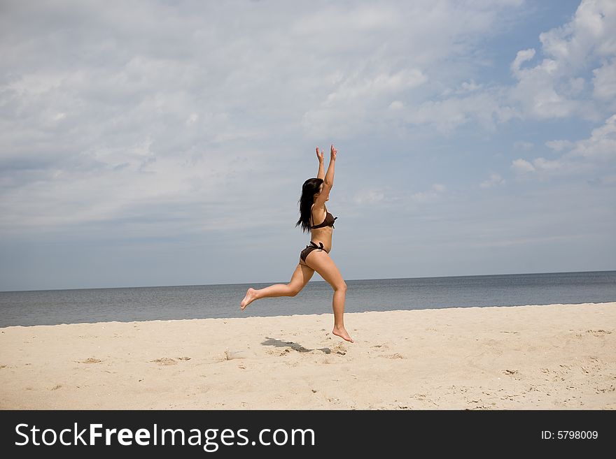 Active woman jumping on the beach. Active woman jumping on the beach