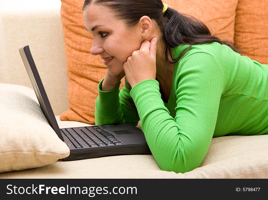 Attractive brunette woman on sofa with laptop. Attractive brunette woman on sofa with laptop