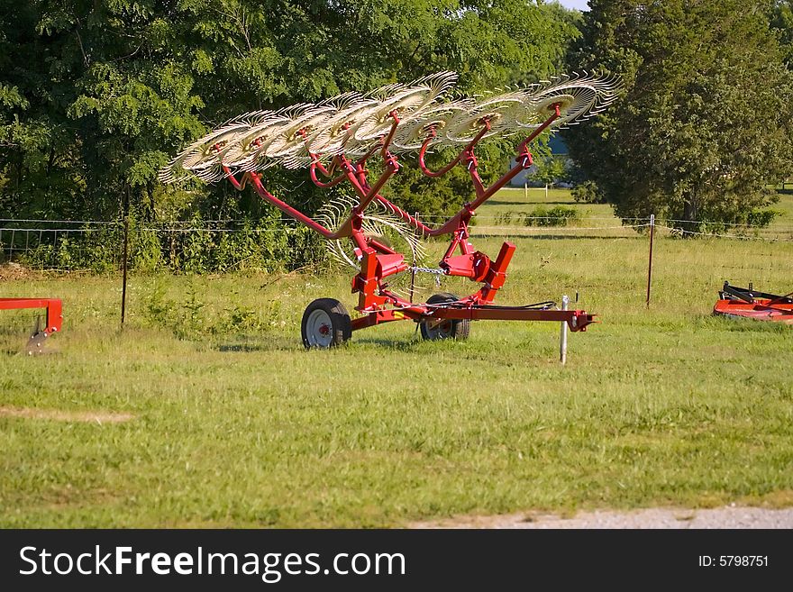 A small hay rake for sale on an impliment lot