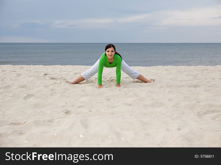 Active woman doing exercise on the beach