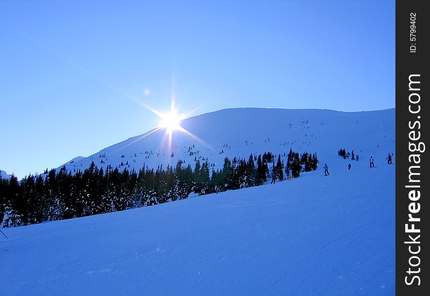 Sun behind of snowy hill. Sun behind of snowy hill.