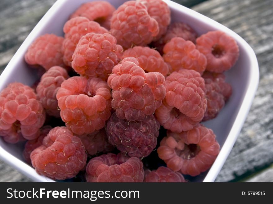 Red raspberries in a white bowl