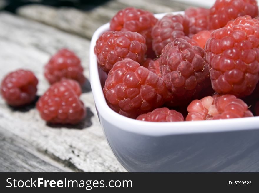 White bowl with red raspberries