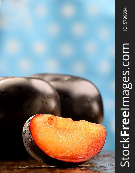 Fresh black plum slice on a stone counter. Fresh black plum slice on a stone counter.