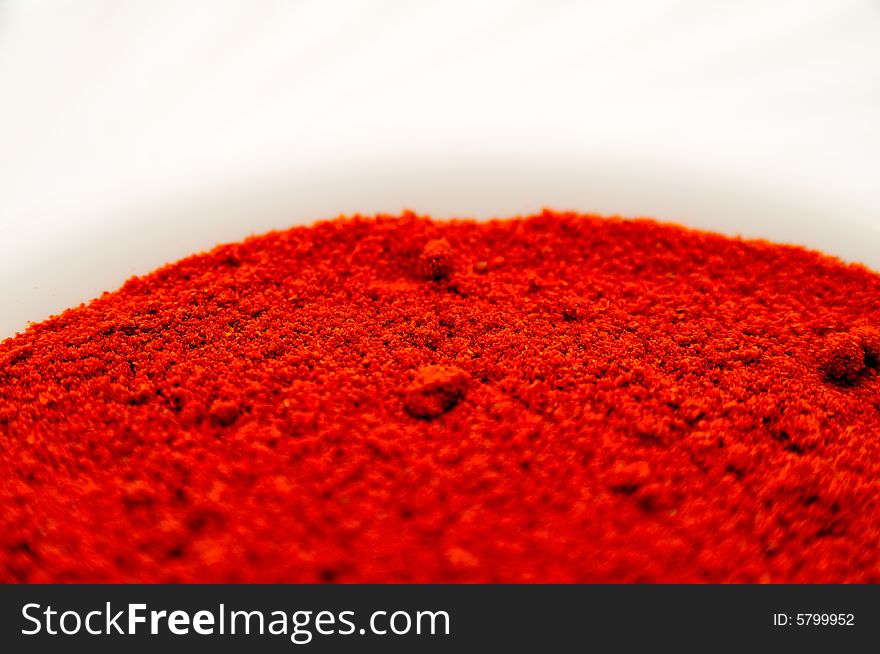 Sweet paprika powder on a plate, with very vivid red color. Sweet paprika powder on a plate, with very vivid red color