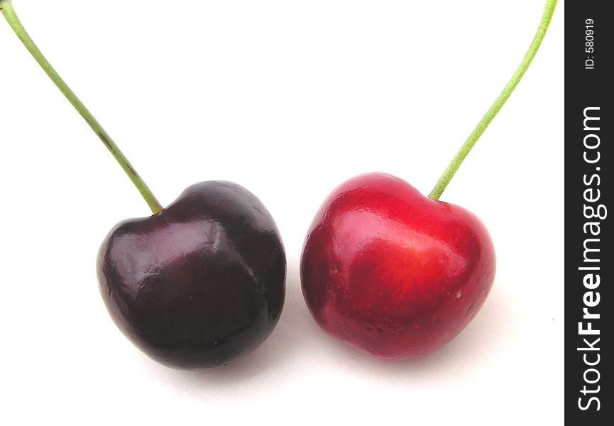 A red and a black cherry isolated over white. A red and a black cherry isolated over white