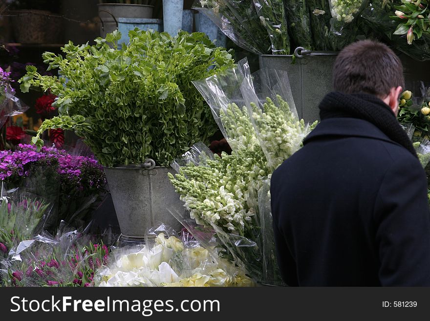 Man shopping for flowers at a outdoors flowerstand. Man shopping for flowers at a outdoors flowerstand