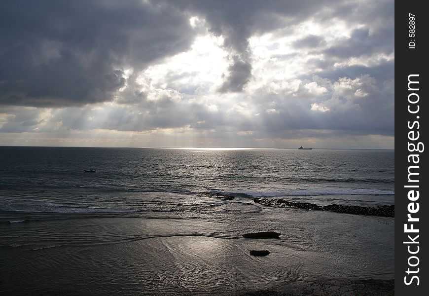 Seaside landscape with sun hiding behind clouds. Seaside landscape with sun hiding behind clouds