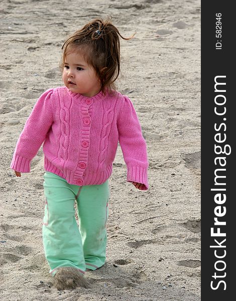 Toddler walking through the sand. Toddler walking through the sand