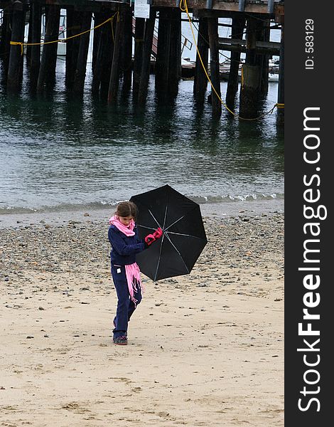 Child walking on the beach and holding an umbrella. Child walking on the beach and holding an umbrella