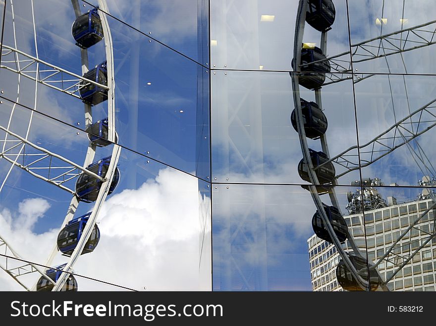 Ferris Wheel reflected in glass of Symphony Hall Birmingham UK. Ferris Wheel reflected in glass of Symphony Hall Birmingham UK