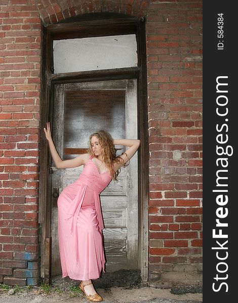 Beautiful young woman in formal dress standing in grunge doorway. Beautiful young woman in formal dress standing in grunge doorway.