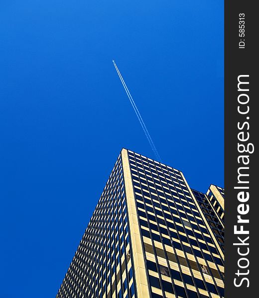 SkyCraper with plane and contrail in gorgeous blue sky. SkyCraper with plane and contrail in gorgeous blue sky.