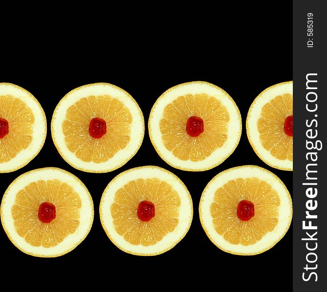 Design of seven grapefruit halves with red cherries at their centres isolated against a black background. Design of seven grapefruit halves with red cherries at their centres isolated against a black background.