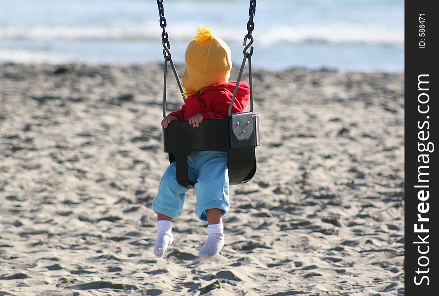 Baby on a swing at the beach in Oceanside, California. Baby on a swing at the beach in Oceanside, California