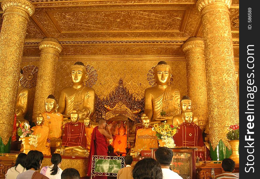 Monk and worshippers in Shwedagon Pagoda, Yangon, Myanmar