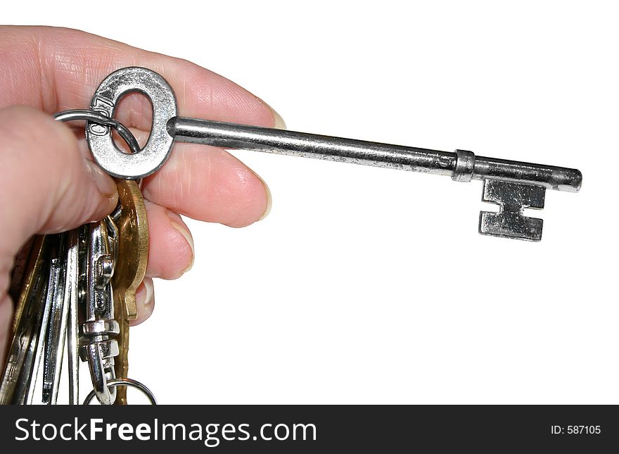 A large key on a bunch of keys isolated over a white background. A large key on a bunch of keys isolated over a white background