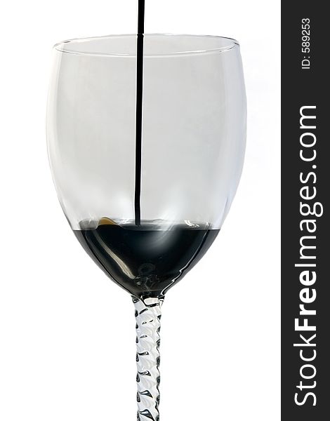 Oil being poured into a wine glass. Oil being poured into a wine glass