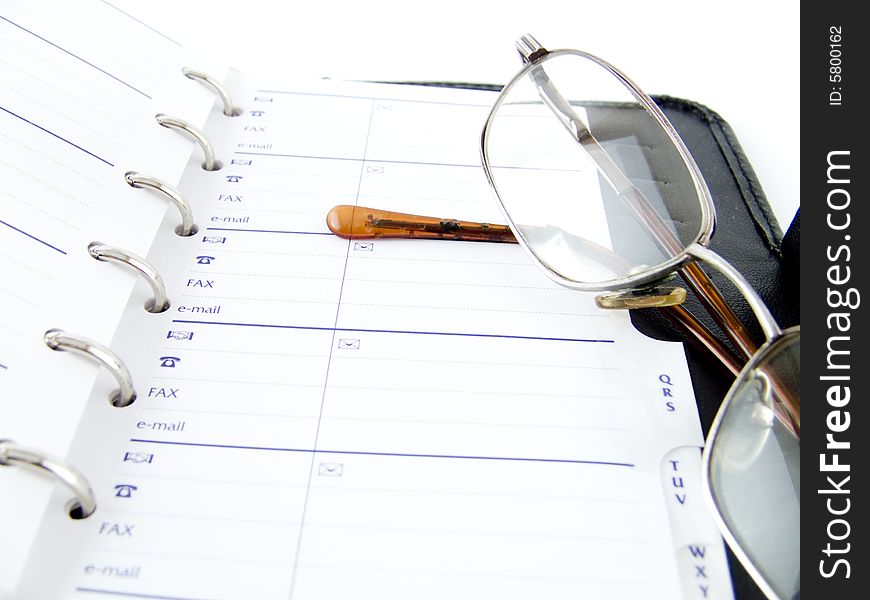 The opened notebook and glasses on a white background