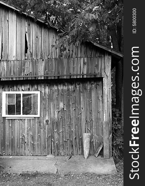 A side of an old, weathered barn in black and white.