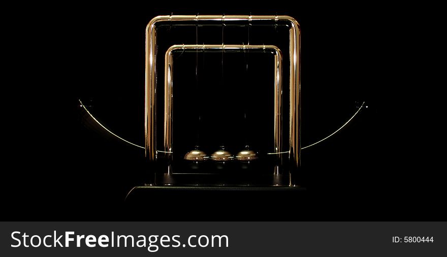 Newton Pendulum showing motion over a black background