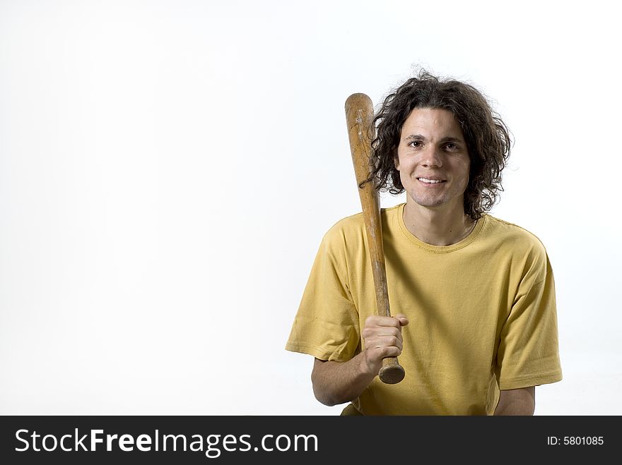 A young male holding a baseball bat to his shoulder.  He is smiling and looking at the camera. Horizontally framed shot. A young male holding a baseball bat to his shoulder.  He is smiling and looking at the camera. Horizontally framed shot.