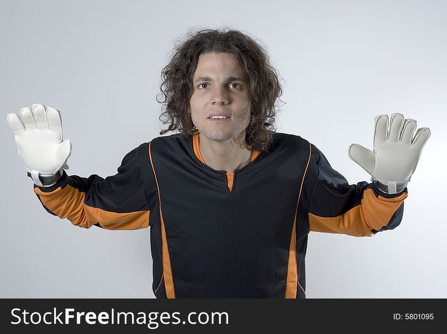 An athlete posing in a goalie stance.  His hands are gloved and he has his arms stretched out defensively. Horizontally framed shot. An athlete posing in a goalie stance.  His hands are gloved and he has his arms stretched out defensively. Horizontally framed shot.