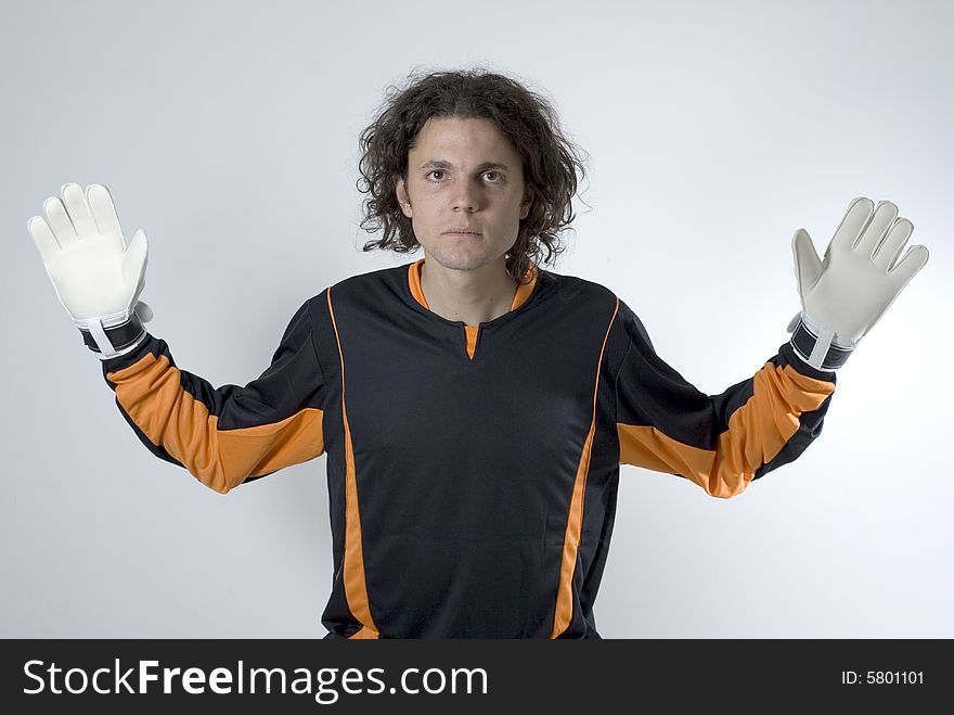 Soccer goalie wearing gloves looks serious as he has his hands out. Horizontally framed photograph. Soccer goalie wearing gloves looks serious as he has his hands out. Horizontally framed photograph.