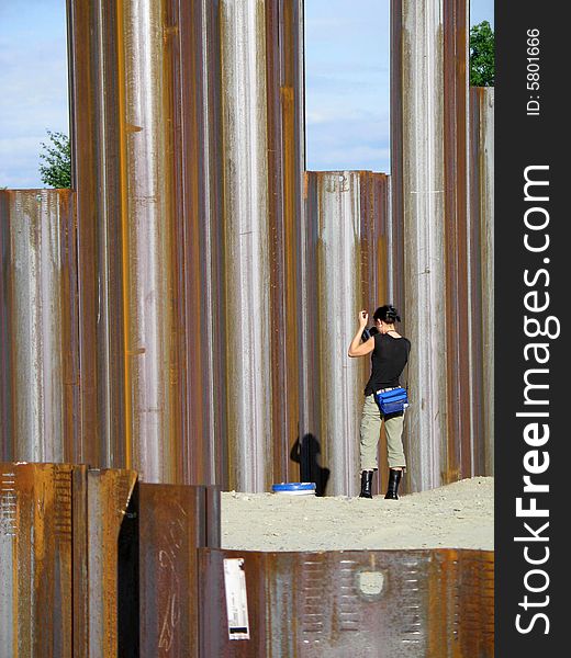 A girl taking pictures of metal girders