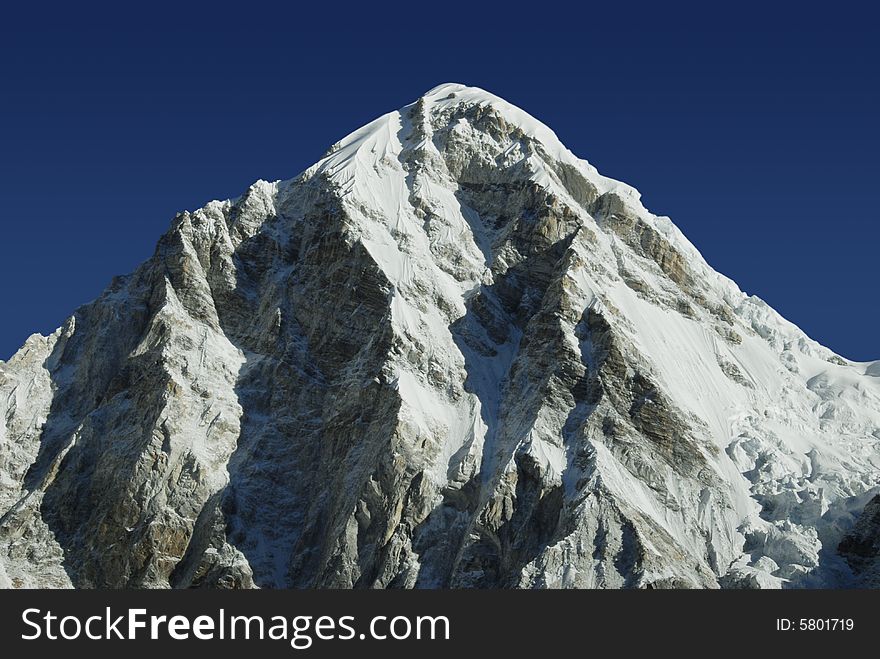 Himalayan mountain Pumori in the Everest mountain range under a bright blue sky. Himalayan mountain Pumori in the Everest mountain range under a bright blue sky